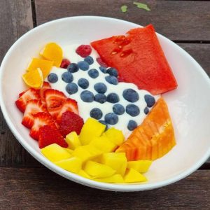 Bowl of colorful fresh fruit salad with yogurt